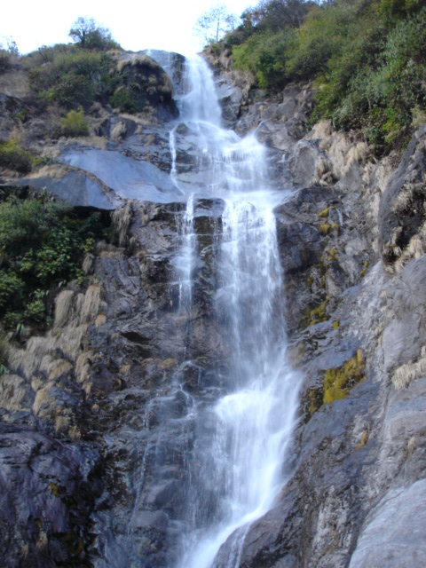 the large waterfall is flowing from the side of the mountains