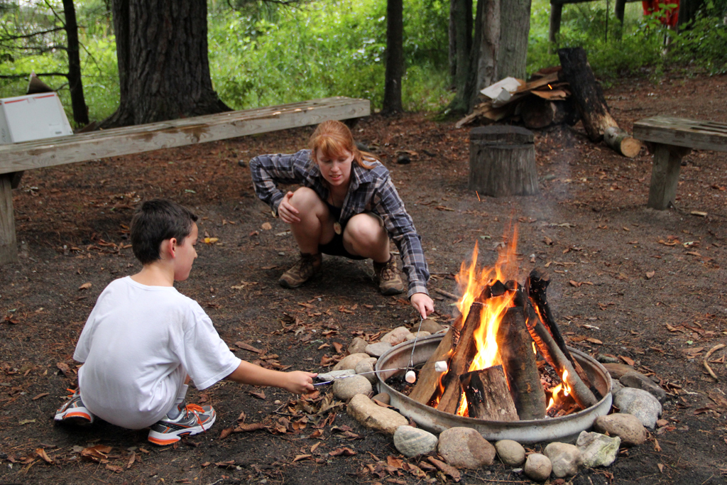 a couple of people sitting around a fire