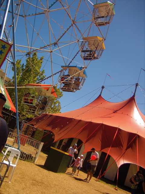 an area with a ferris wheel and chairs inside