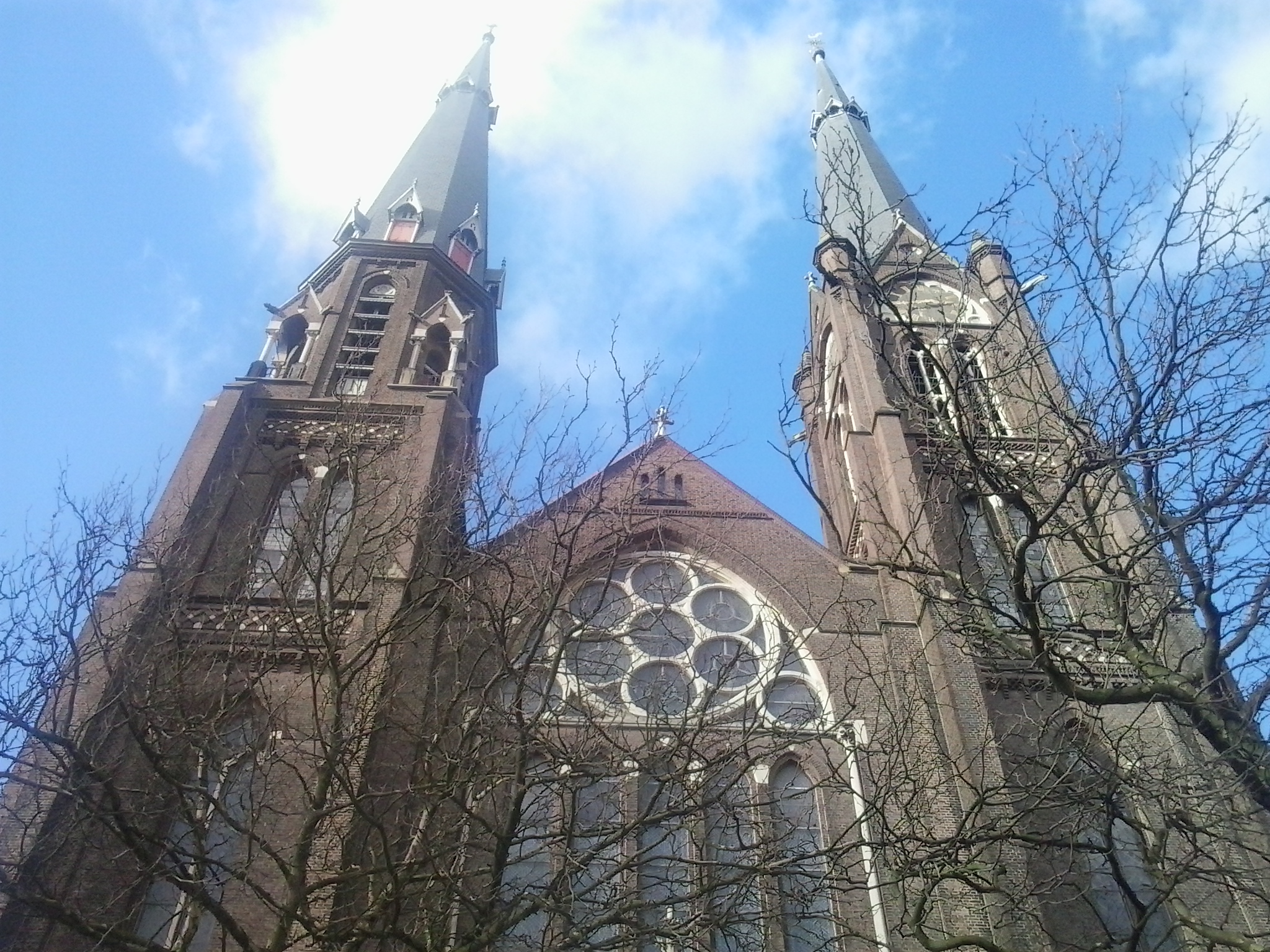 a church with stained glass windows against a cloudy sky