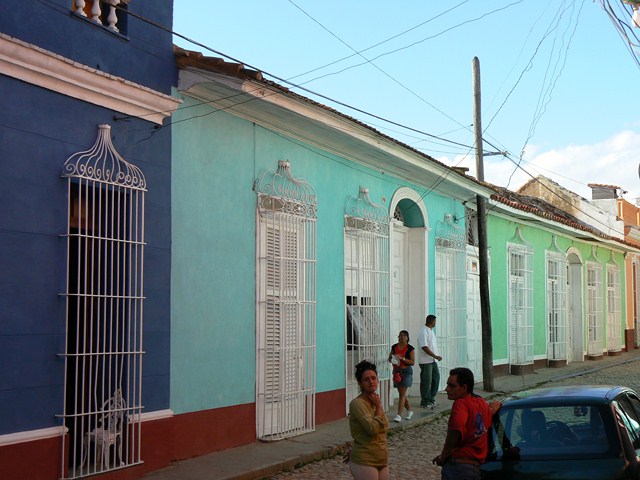 a group of young people walking on the street in front of several old houses