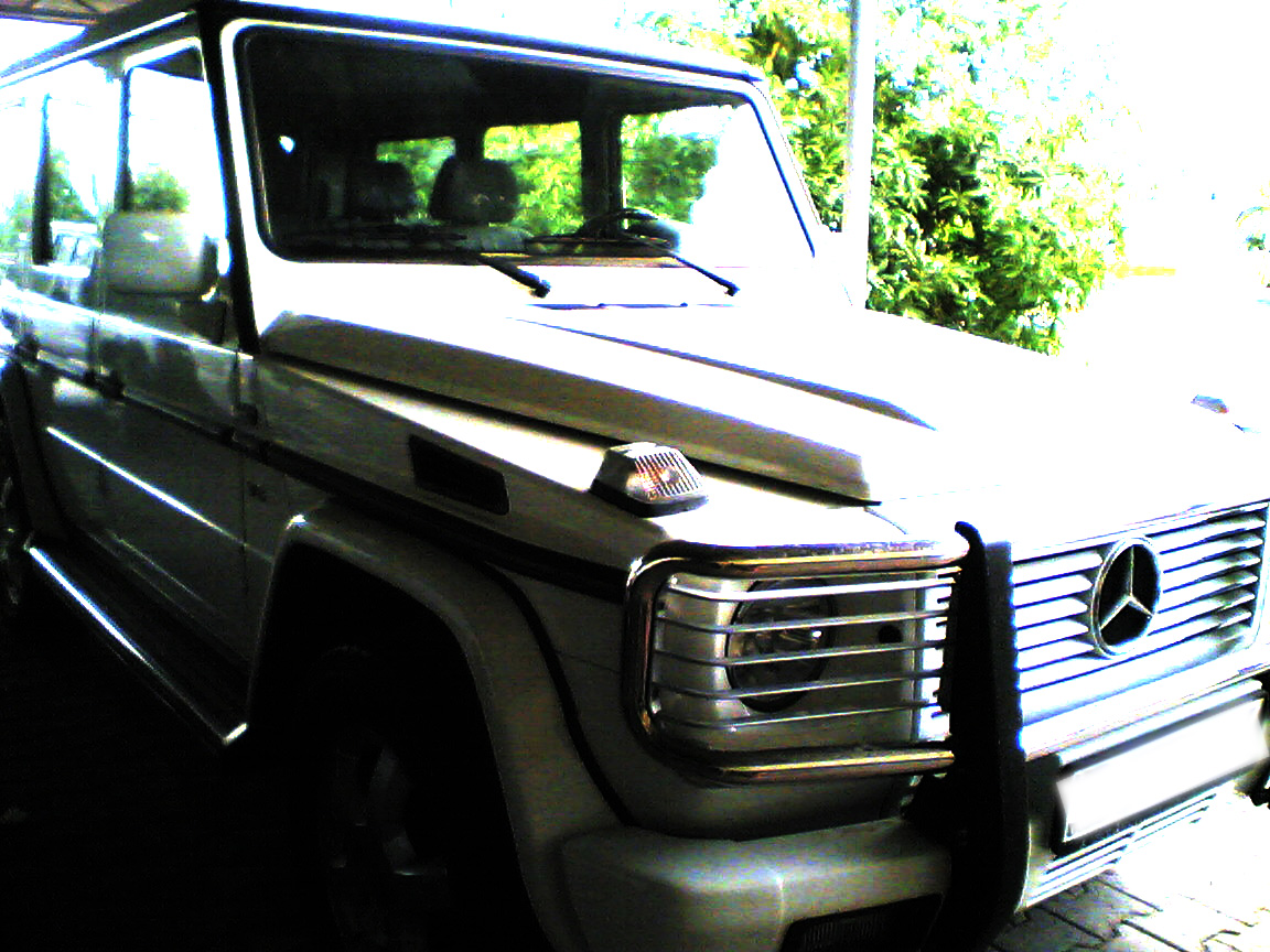 a white vehicle with a black strip around the front and side windows