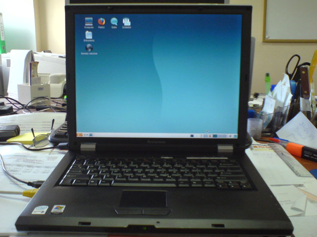 an open laptop computer on a cluttered desk