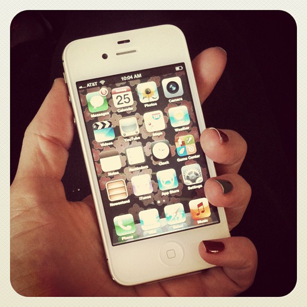 a woman's hand holding an iphone in front of her