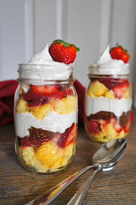 a few jars of food on a wooden table with spoons