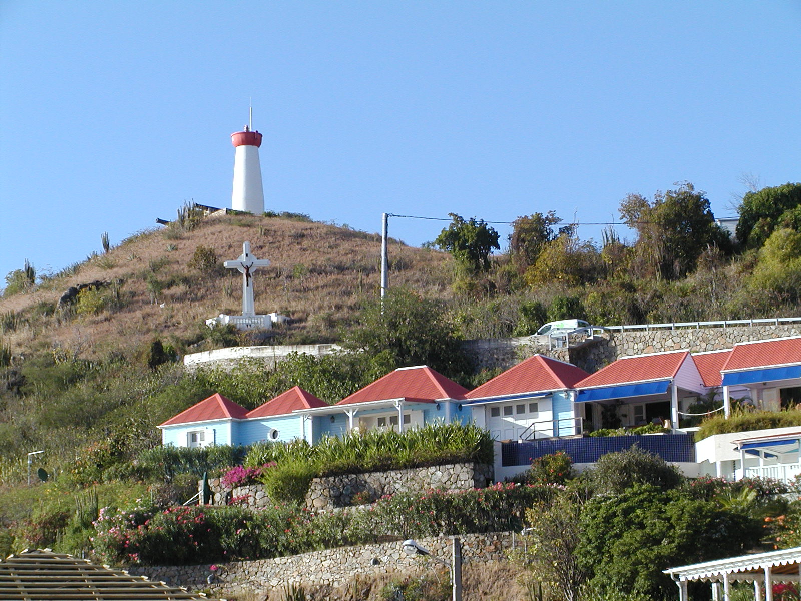 some houses near a lighthouse on a hill with a clear sky