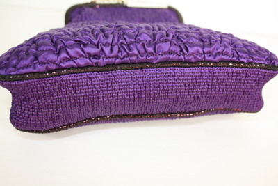 two purple purses are lying next to each other