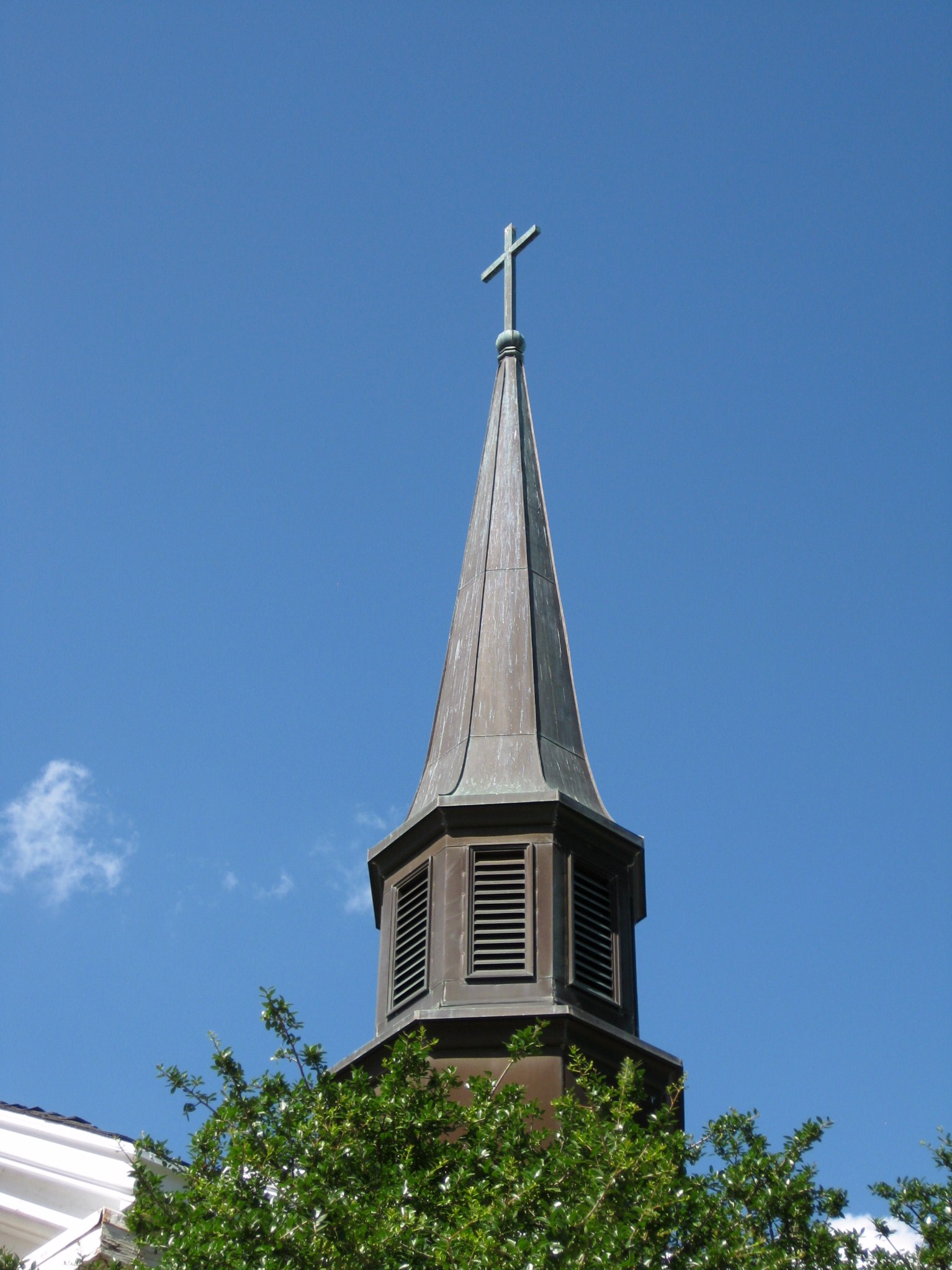 a very tall church tower with a cross on top