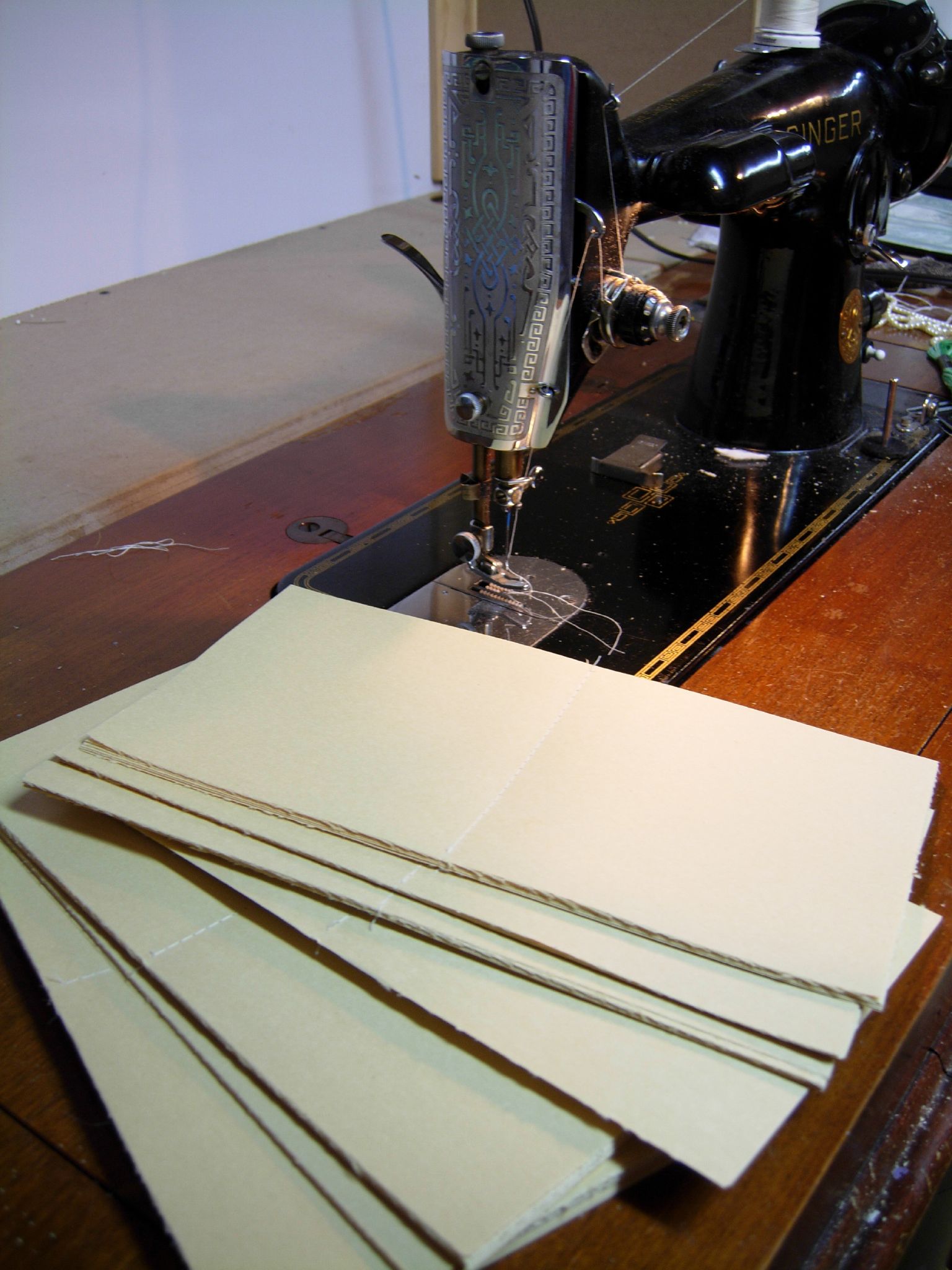four sheets of parchment are sitting on a sewing machine
