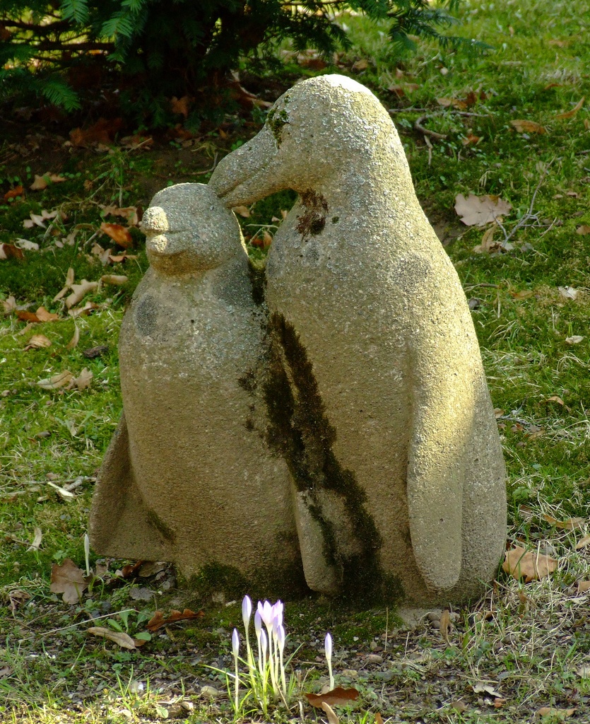 two cement bears one holding each other
