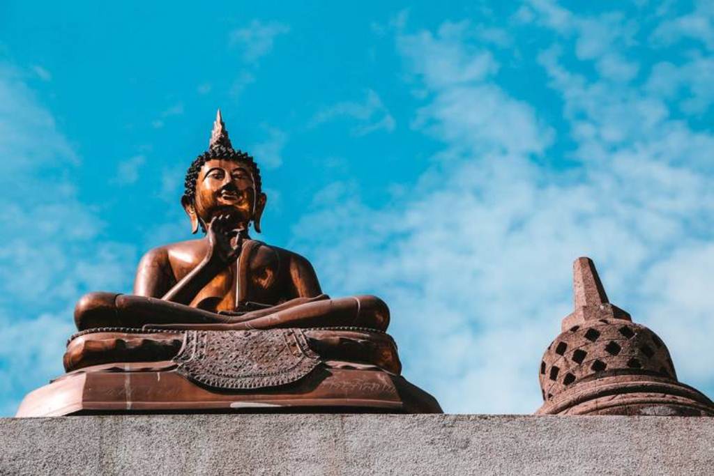 a person statue is sitting outside with  on