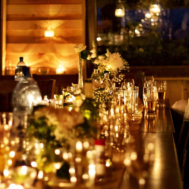 an outdoor wedding reception table setting lit by candles