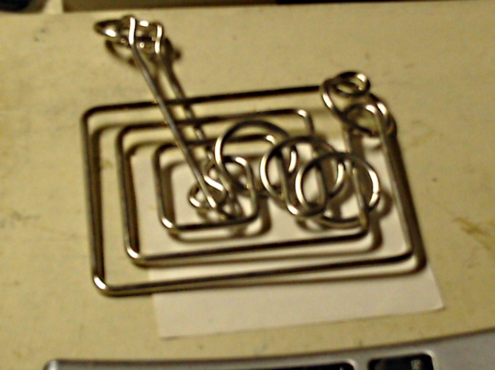 some type of silver paper clip in a metal holder
