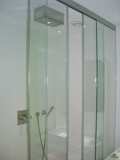 a glass shower enclosure with a toilet in the corner