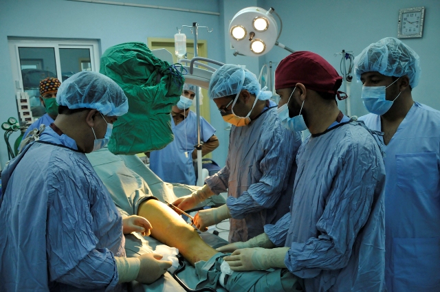 the team of doctors perform  on a patient