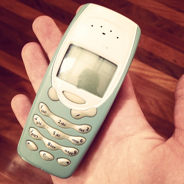 a person is holding an old fashioned cell phone