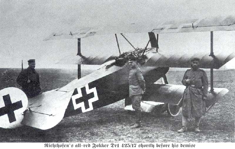 men standing next to a biplane on a field