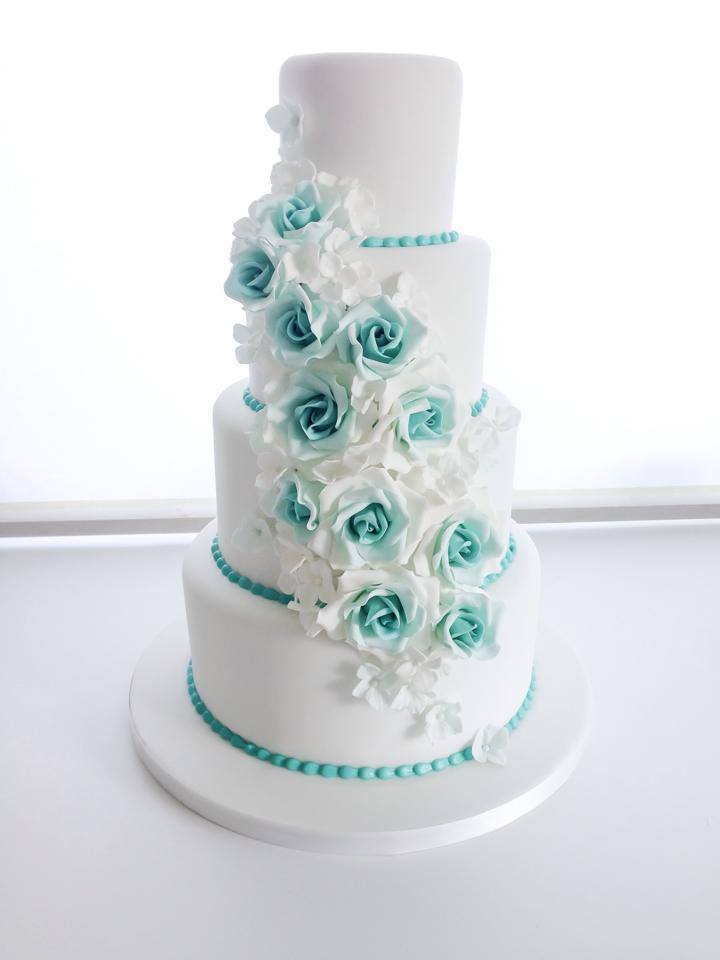 white and aqua wedding cake decorated with roses