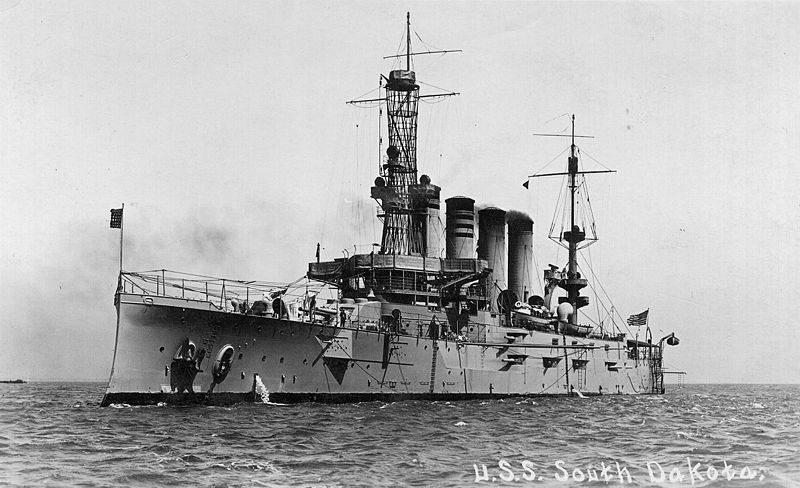 a battleship on the ocean with smoke stacks coming out