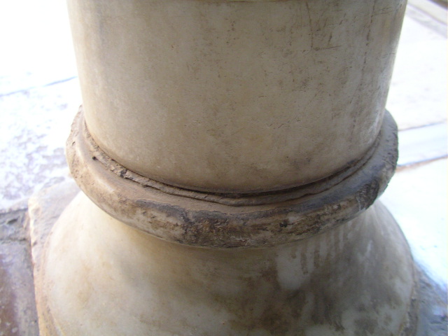 a white ceramic container sitting on top of a cement slab