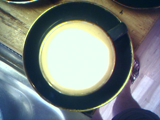 a close up of a coffee cup next to a plate