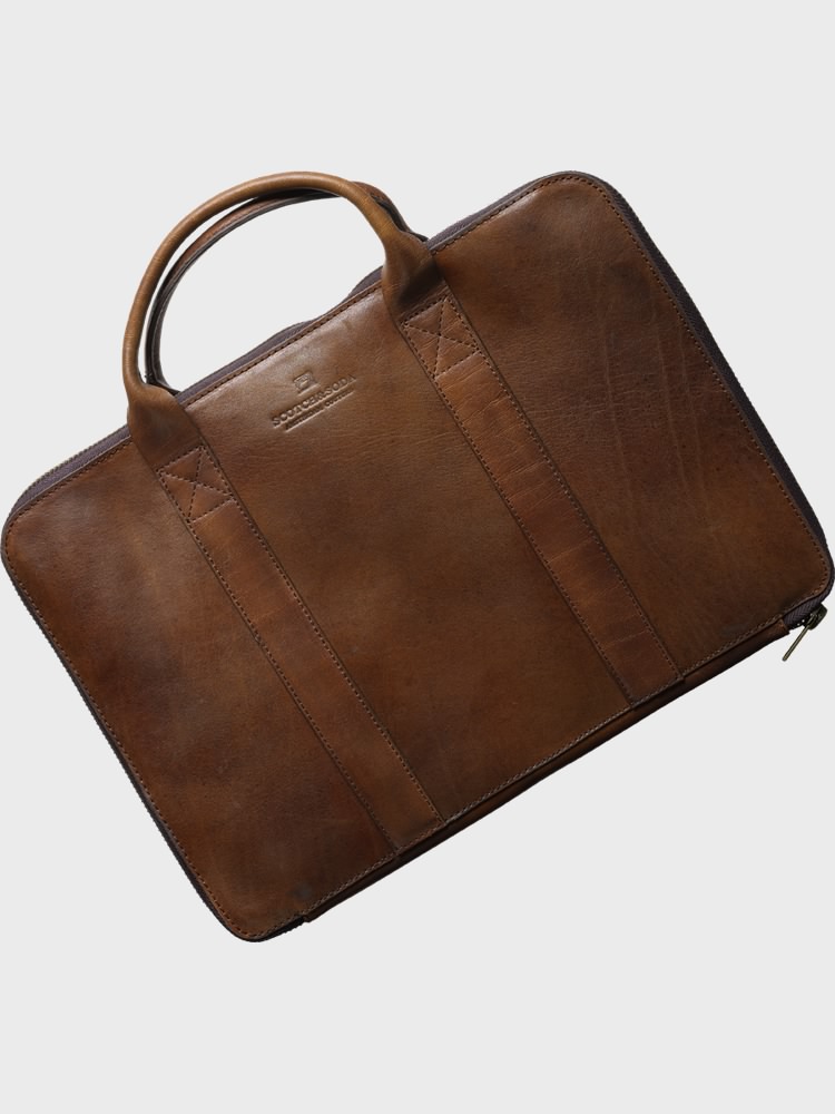a briefcase bag with leather handles on a grey background