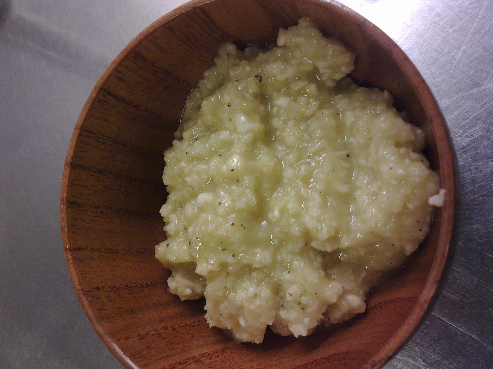 a wooden bowl filled with mashed potatoes on top of a counter
