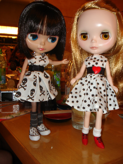 two dolls with different colored eyes on a table