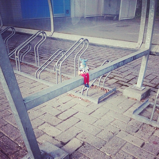 a small sculpture of a stuffed animal on an empty street