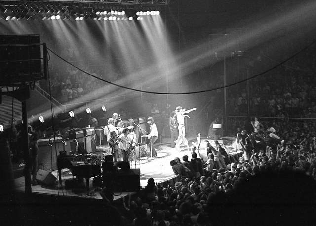 a large crowd watches an band on stage