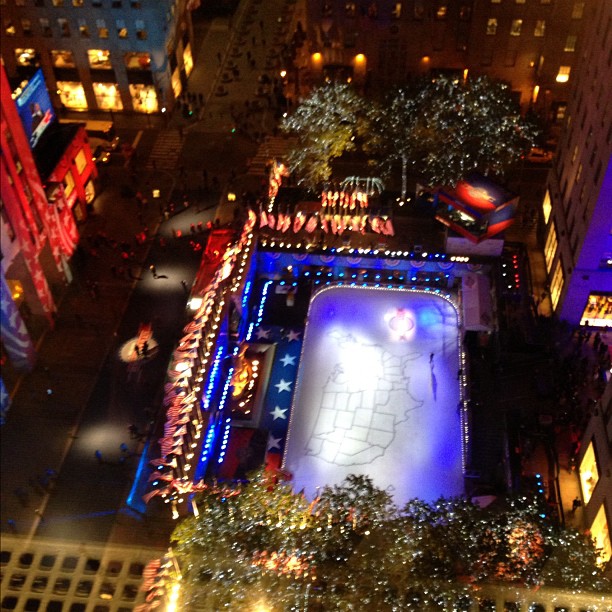 a large lighted pool surrounded by tall buildings