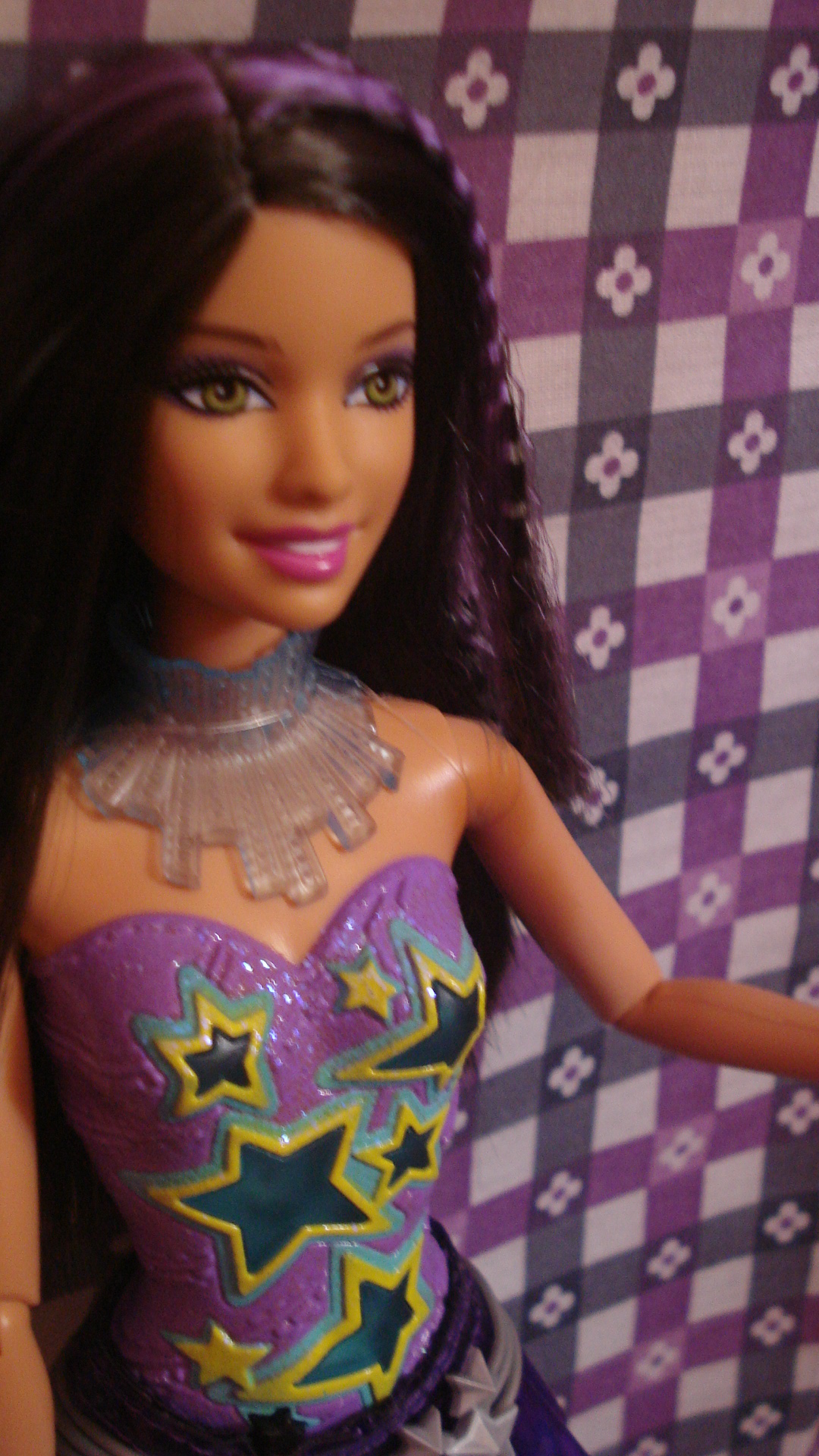 a doll is standing in front of a purple and black wall