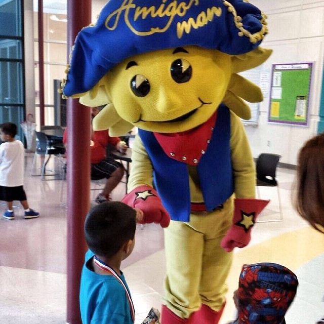 two children near a mascot in the hallway