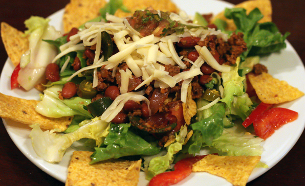 an appetizing plate filled with chips and a salad