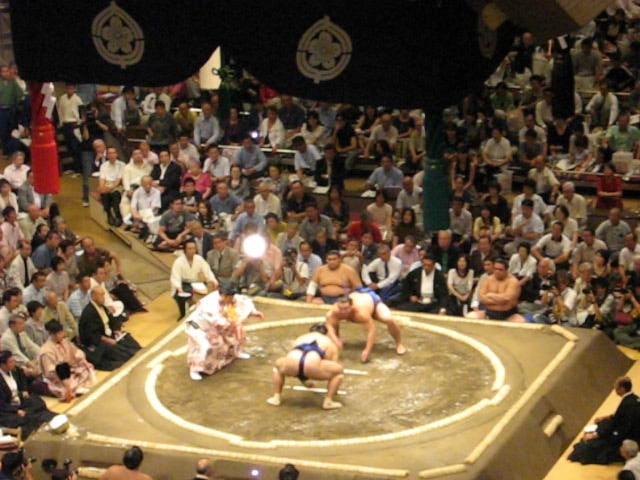 sumo wrestlers in blue and red pants at the same event
