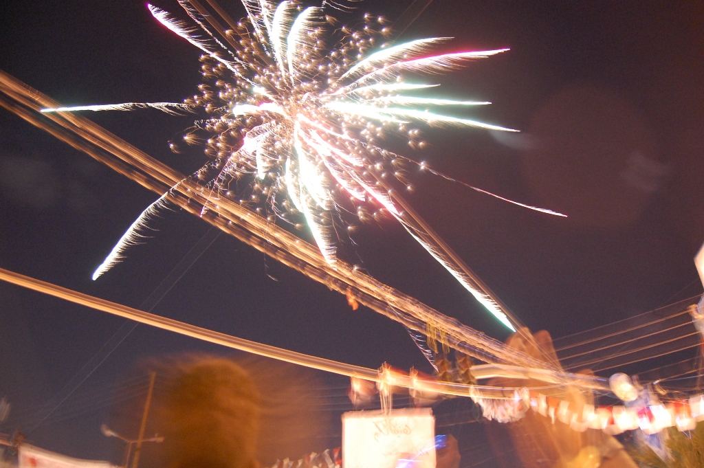 fireworks in the sky at night with people around