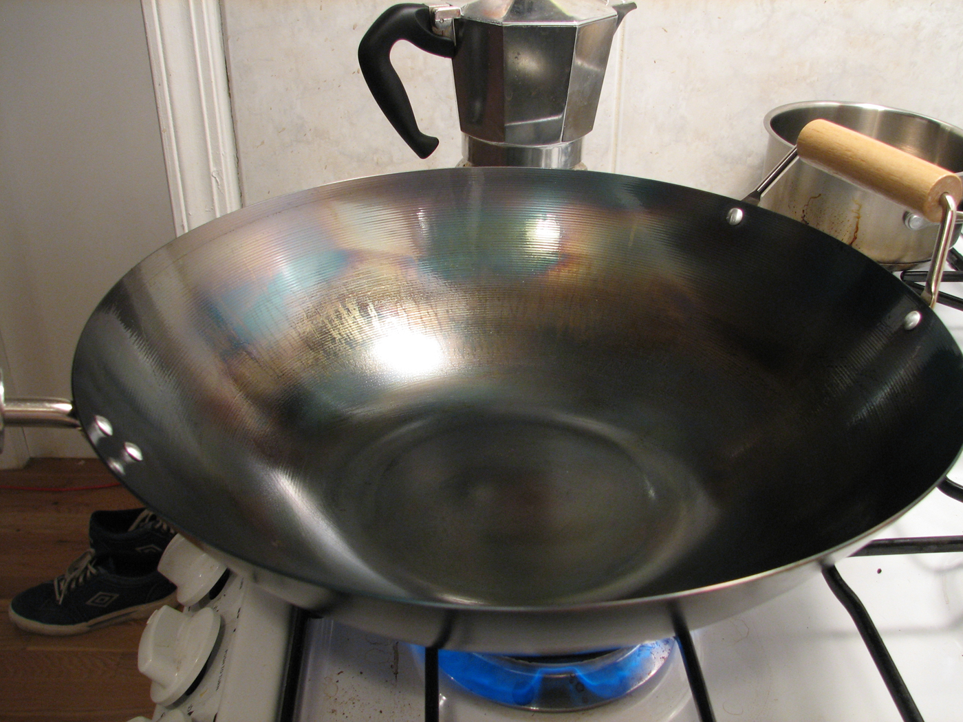 a large metal bowl on top of a kitchen stove