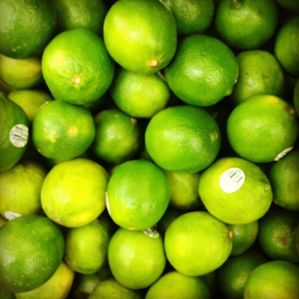 limes in a bowl, with yellow ones on the side