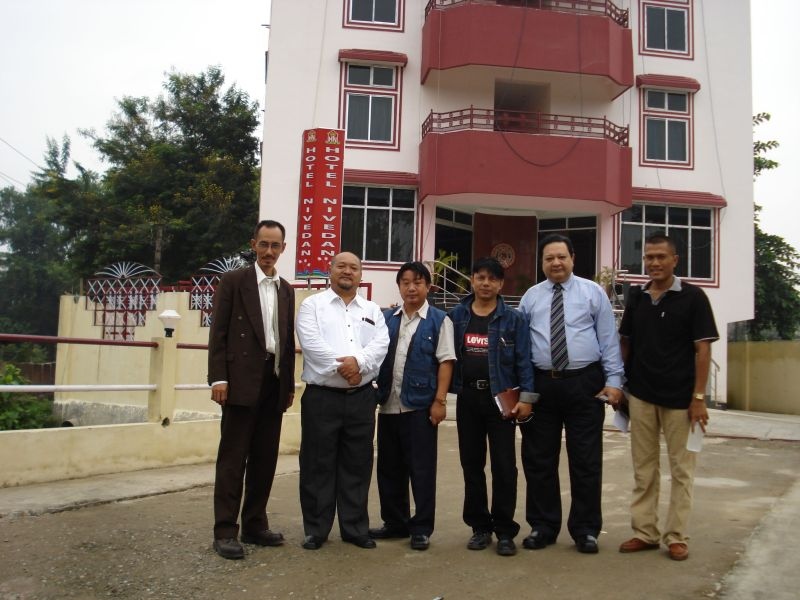 a group of men standing in front of a building