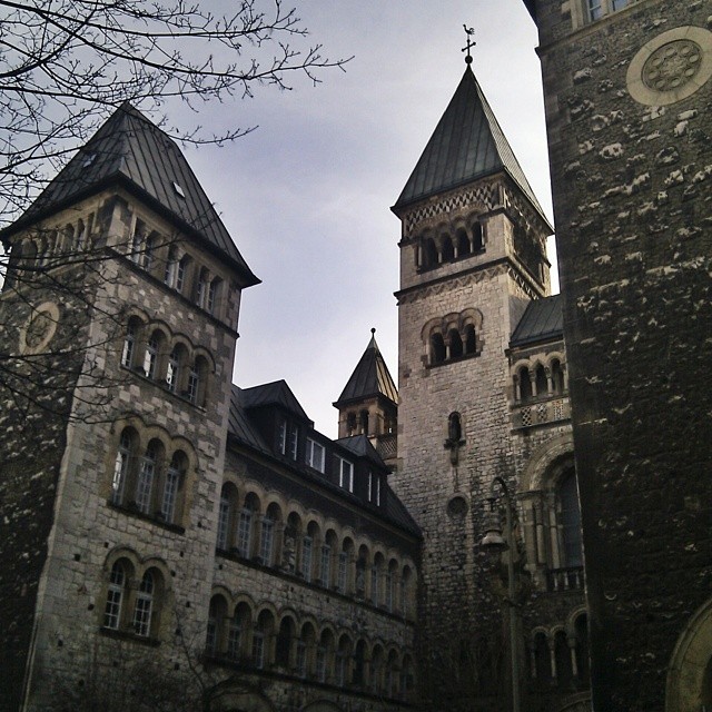 an old building with a clock tower is seen through another tall building