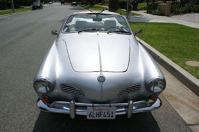 a car parked on the street next to the grass