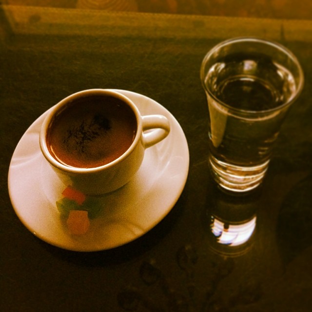 a coffee cup and a glass of water on a table