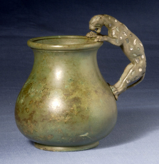 a ss vase with a handle, and a horse on the top