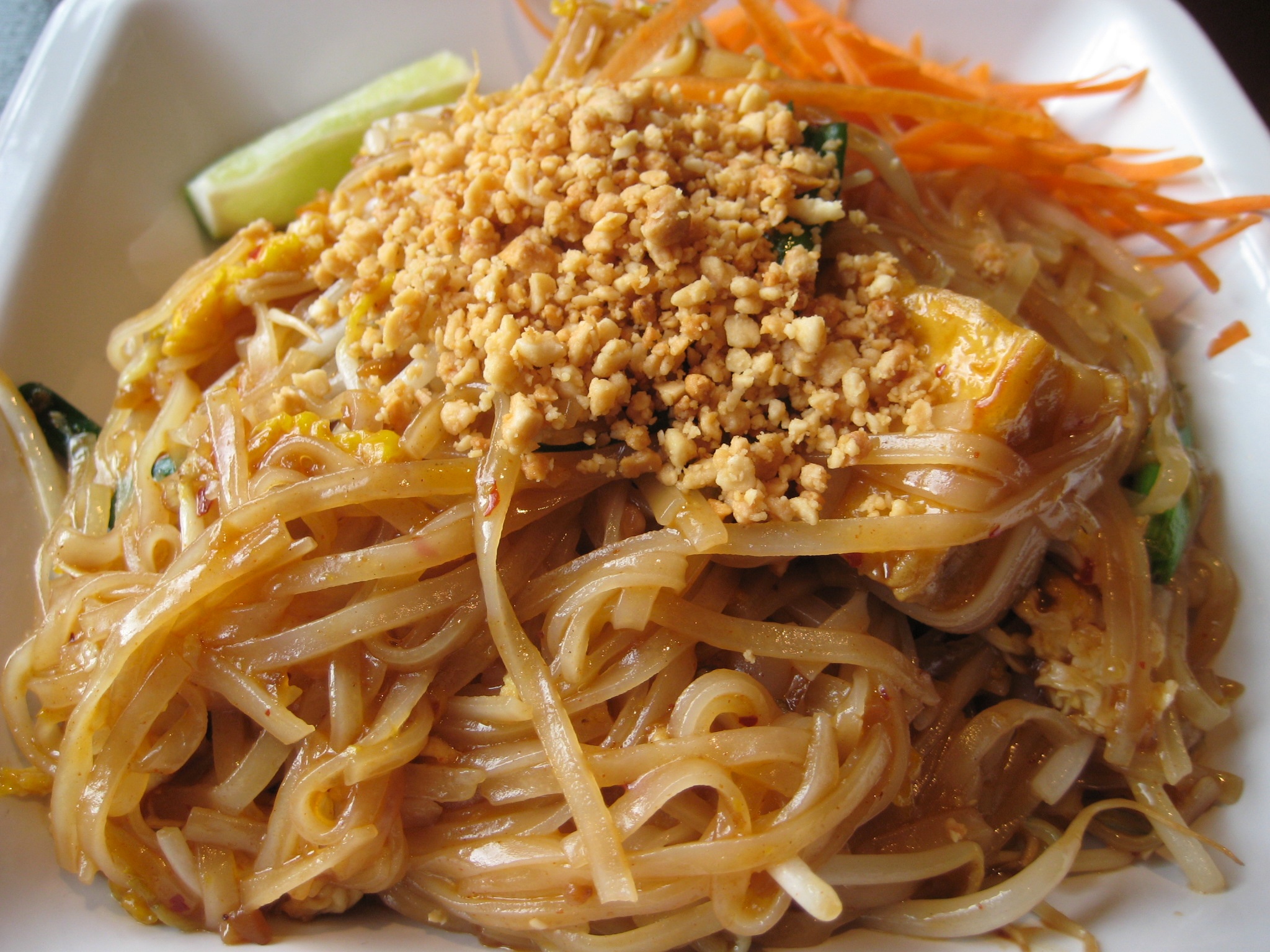 a plate of noodles on a white plate with garnish