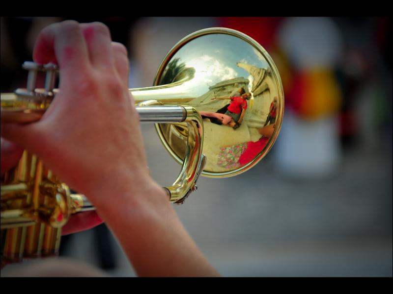 the trombone is close to the camera in its right hand