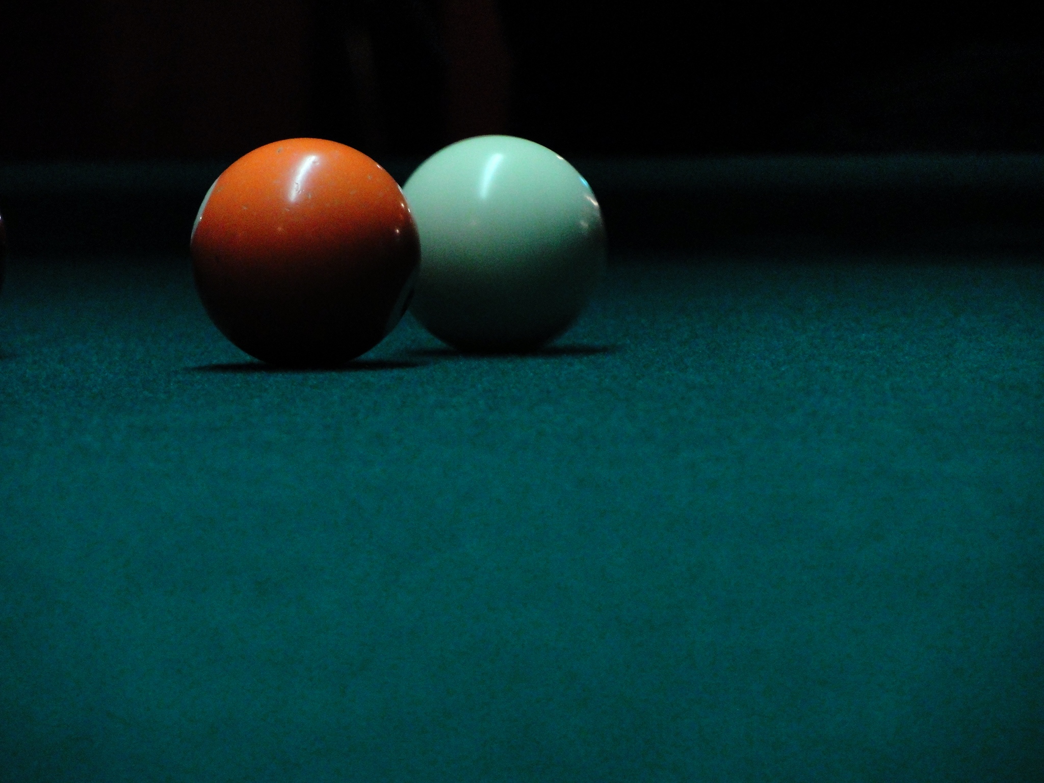 two white and red pool balls on the green table