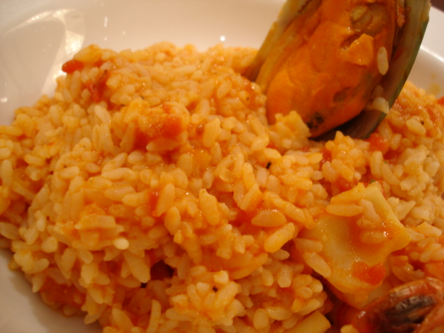 a spoonful of food with rice and other food on the plate