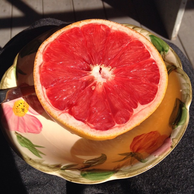 a gfruit on a plate with a knife sticking out of it