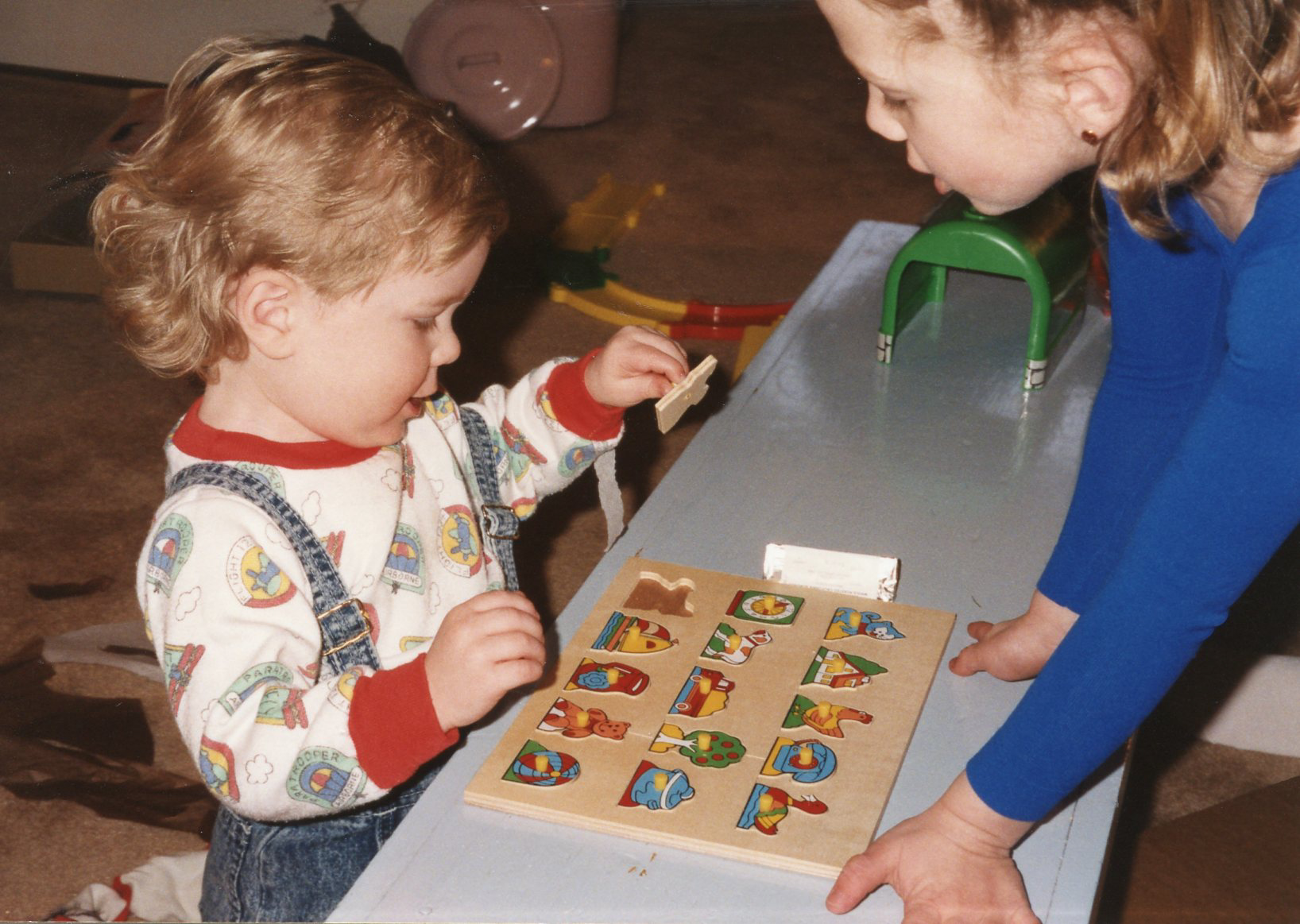 two small children playing with their numbers and letters on wooden toys