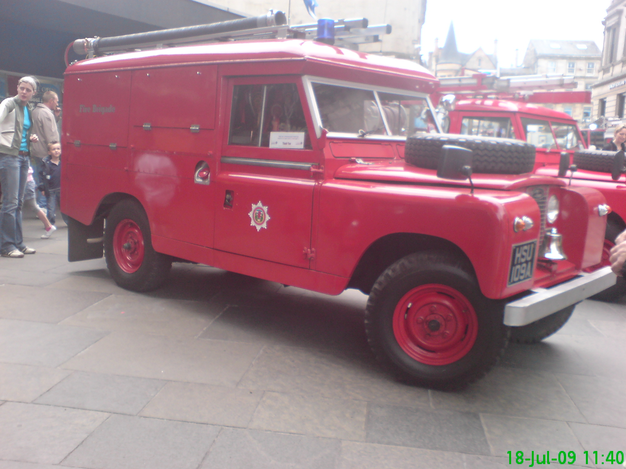 a row of old red firetrucks parked in an alley